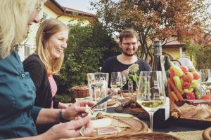Menschen sitzen an einem gedeckten Tisch