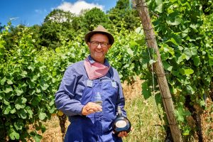 Mann in Gewand mit einer Weinflasche